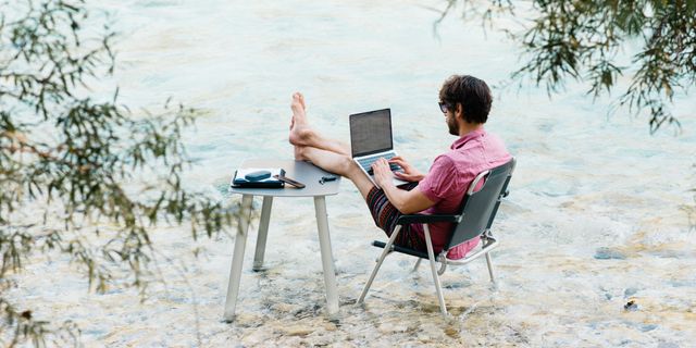Mann arbeitet am Laptop im Wasser
