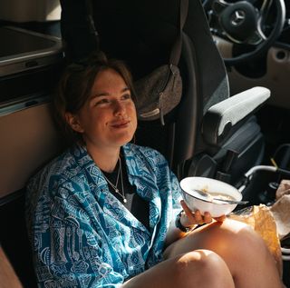 Mädchen isst Müsli im Camper