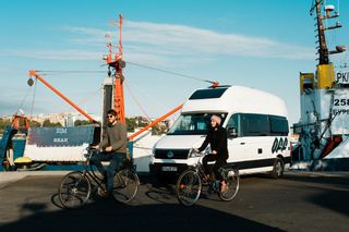 Pärchen fährt mit Fahrrad am Hafen